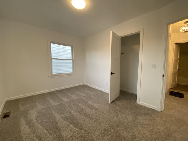 unfurnished bedroom featuring dark carpet and a closet