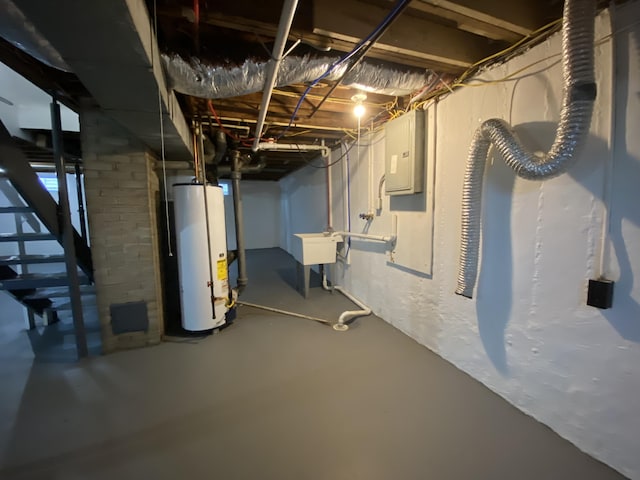 basement featuring gas water heater, sink, and electric panel