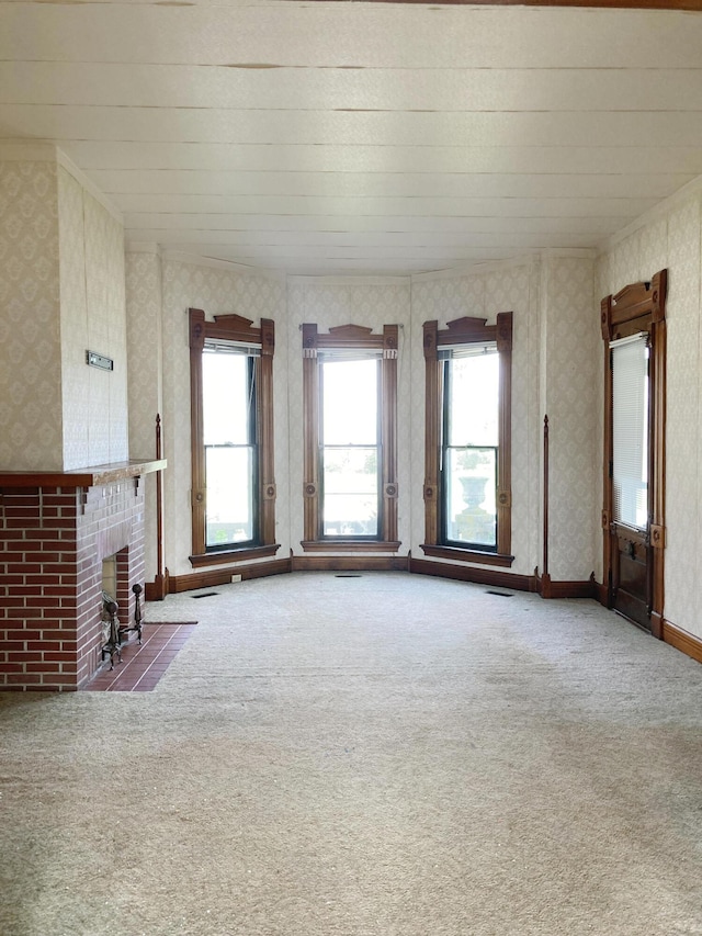 119 E Orchard St, West Manchester, OH 45382 - unfurnished living room featuring healthy amount of natural light, carpet, wallpapered walls, and a brick fireplace