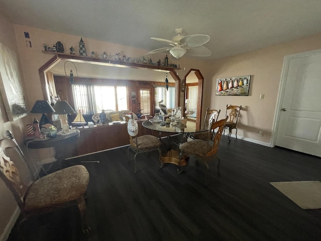 dining space featuring arched walkways, ceiling fan, baseboards, and wood finished floors