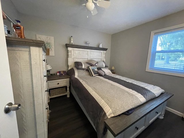 bedroom featuring dark wood-type flooring, a ceiling fan, and baseboards