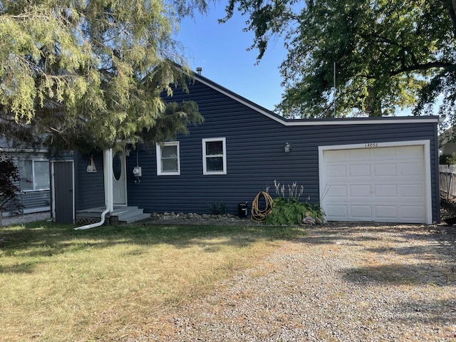 view of front of house with entry steps, driveway, an attached garage, and a front yard