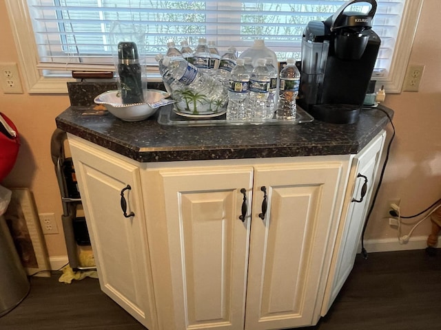 interior details featuring a bar, baseboards, and wood finished floors