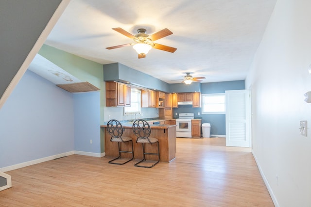 kitchen with open shelves, white range with electric cooktop, brown cabinetry, a peninsula, and a kitchen breakfast bar