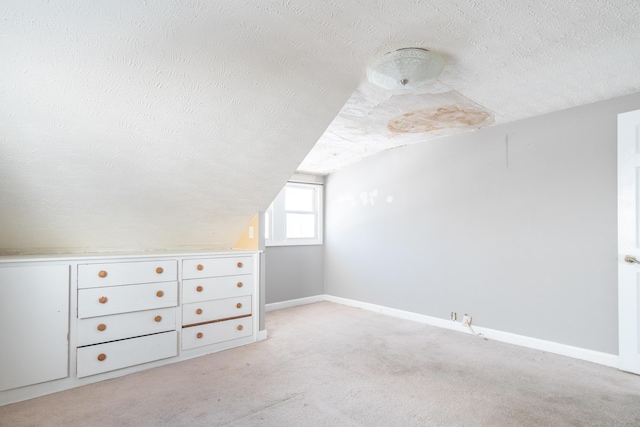 bonus room with baseboards, vaulted ceiling, a textured ceiling, and light colored carpet