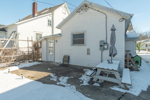 snow covered house with fence