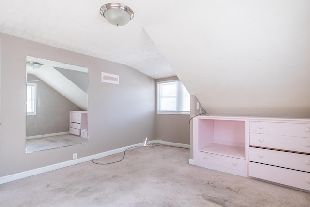 bonus room featuring light carpet, vaulted ceiling, and baseboards