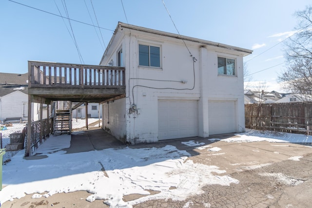 view of front of house featuring stairs, an attached garage, fence, and a wooden deck