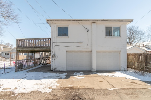 view of front of house with a garage, fence, stairway, and a wooden deck