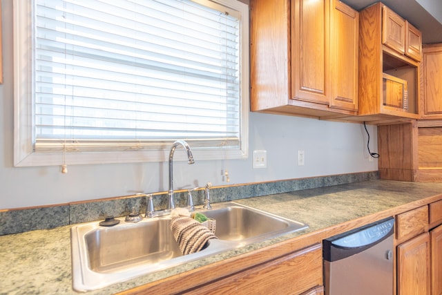 kitchen with dishwasher, brown cabinetry, and a sink