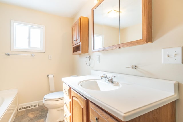 full bathroom with baseboards, visible vents, toilet, a bathing tub, and vanity