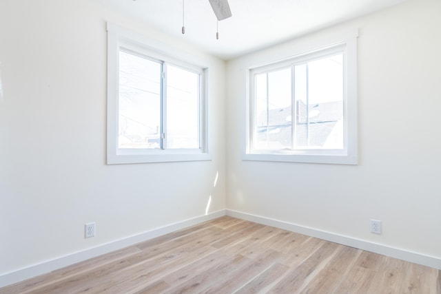 unfurnished room featuring a ceiling fan, light wood-style flooring, and baseboards