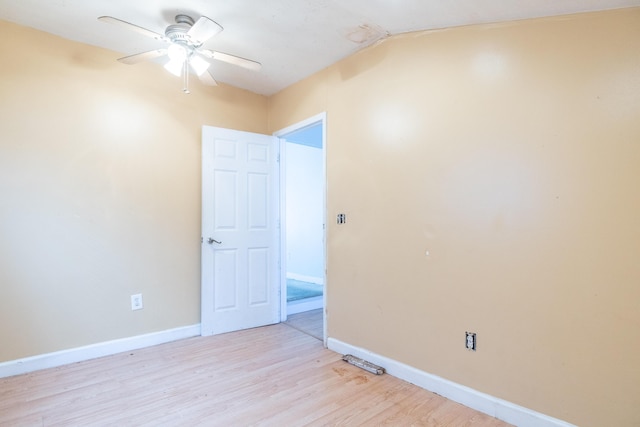 empty room with light wood-style floors, baseboards, and a ceiling fan