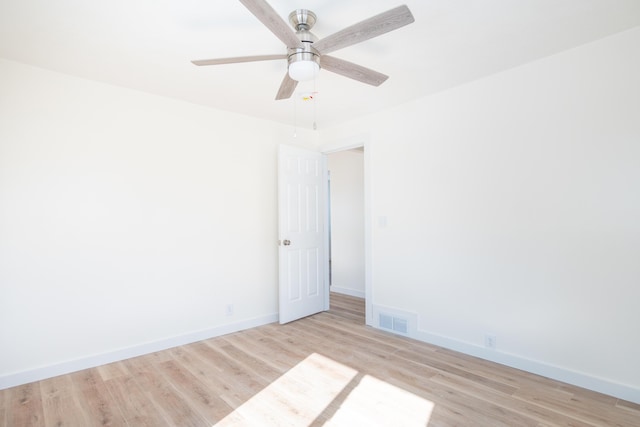 unfurnished room featuring light wood-style floors, baseboards, visible vents, and a ceiling fan