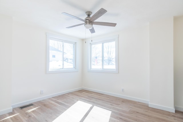 unfurnished room with light wood-style flooring, a ceiling fan, visible vents, and baseboards