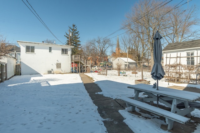 yard layered in snow featuring fence and a residential view