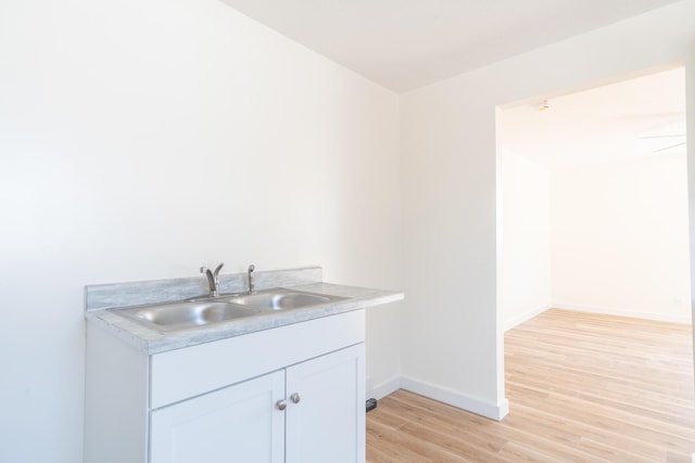 bathroom with baseboards, wood finished floors, and vanity