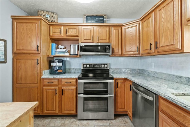 kitchen with light tile patterned floors, tasteful backsplash, appliances with stainless steel finishes, a textured ceiling, and open shelves