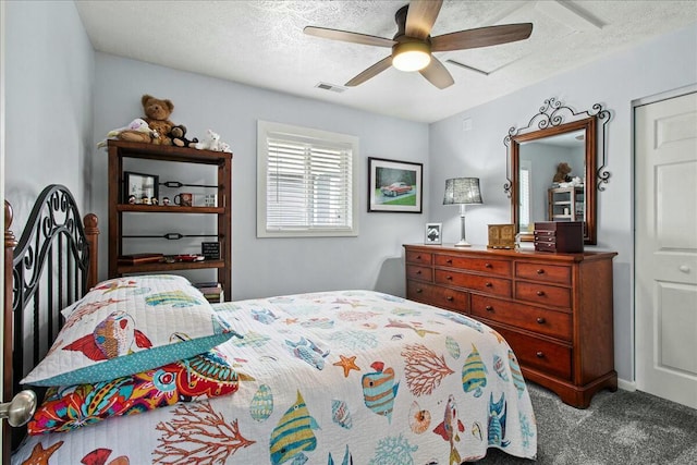 carpeted bedroom featuring a textured ceiling, ceiling fan, and visible vents