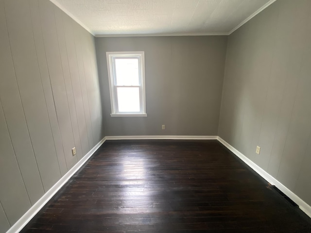 823 Robinson Ave, Piqua, OH 45356 - spare room featuring dark wood-type flooring, ornamental molding, and baseboards