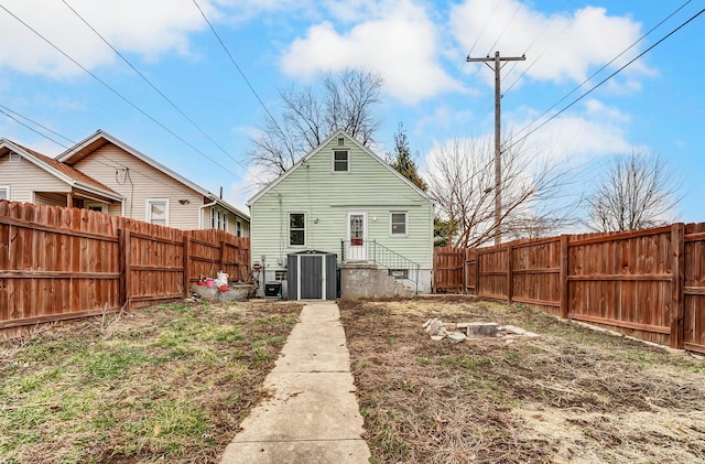 back of house featuring central AC unit and a fenced backyard