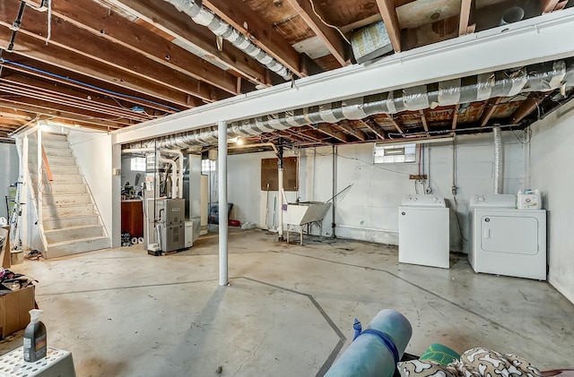 below grade area with stairway, heating unit, washing machine and dryer, and a sink