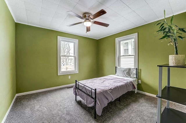 carpeted bedroom featuring baseboards, ceiling fan, and ornamental molding