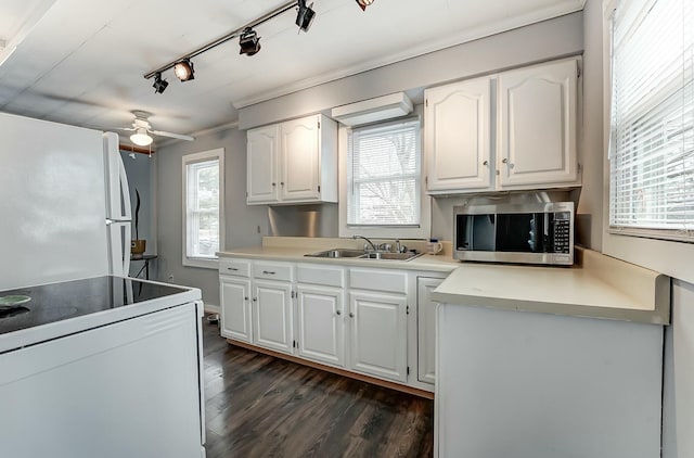 kitchen with dark wood-style flooring, white cabinets, white appliances, and a sink