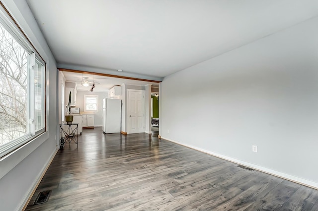 unfurnished living room featuring dark wood-style floors, visible vents, and baseboards