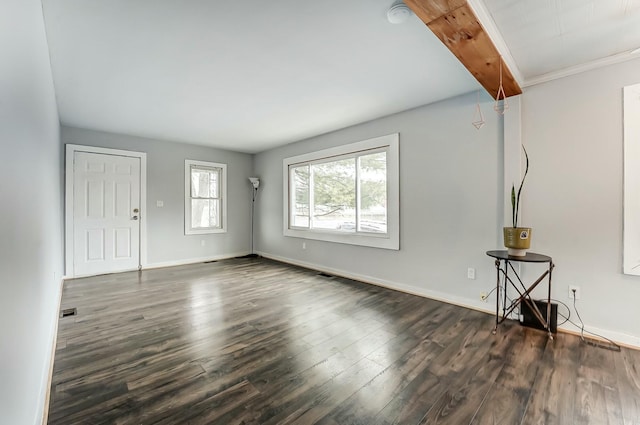 unfurnished room with dark wood-style floors, beamed ceiling, visible vents, and baseboards