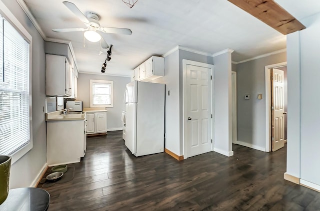 kitchen with dark wood-style flooring, freestanding refrigerator, light countertops, white cabinets, and crown molding