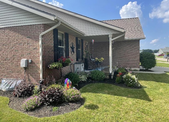 view of side of home with a yard