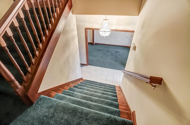 staircase with a chandelier and tile patterned flooring