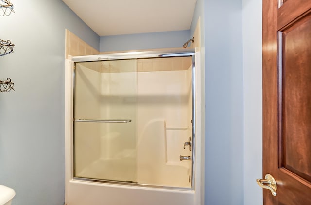 bathroom featuring bath / shower combo with glass door and toilet