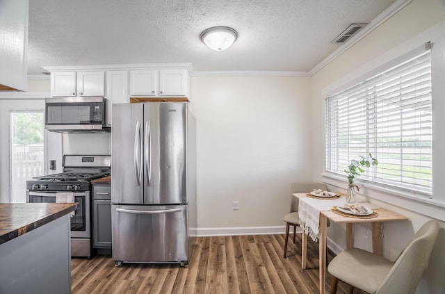 4209 State Route 41, Troy, OH 45373 - kitchen featuring appliances with stainless steel finishes, butcher block counters, a textured ceiling, crown molding, and wood finished floors