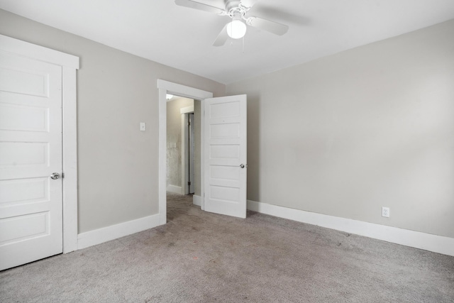 unfurnished bedroom featuring light carpet, a ceiling fan, and baseboards