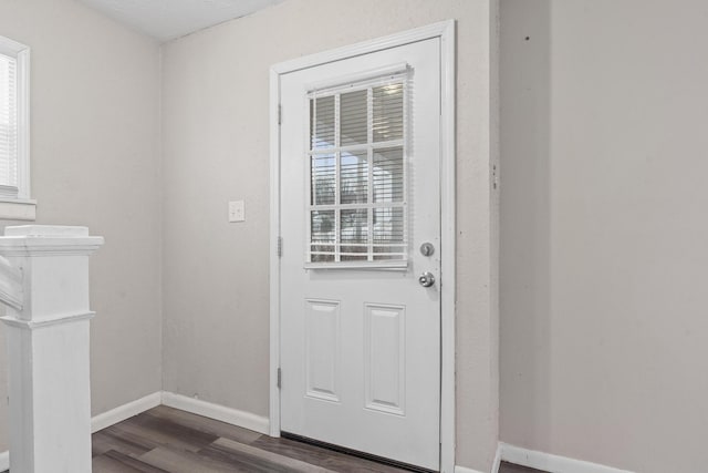 entryway with dark wood finished floors and baseboards