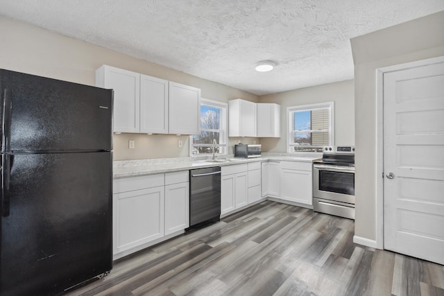 kitchen featuring light countertops, appliances with stainless steel finishes, wood finished floors, and white cabinets