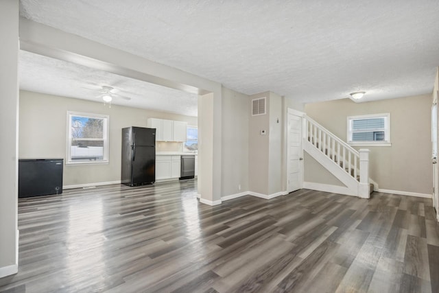 unfurnished living room featuring stairway, baseboards, visible vents, and dark wood-style flooring