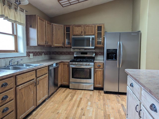 kitchen with tasteful backsplash, lofted ceiling, stainless steel appliances, and sink