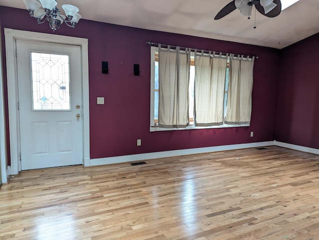 foyer entrance with ceiling fan with notable chandelier and light hardwood / wood-style flooring