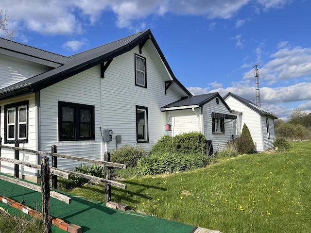 exterior space featuring metal roof and a lawn
