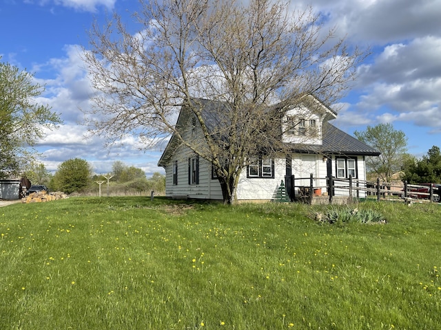 view of property exterior with fence and a lawn