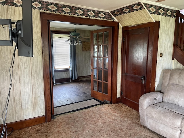 interior space with baseboards, a ceiling fan, carpet floors, and crown molding