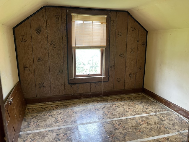 bonus room featuring wooden walls, plenty of natural light, and vaulted ceiling