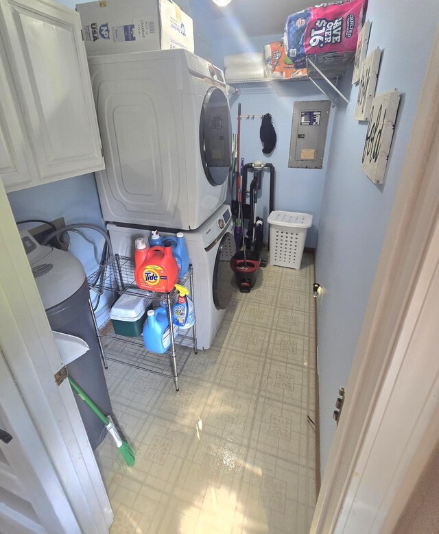 10141 Mohawk Dr, Huntsville, OH 43324 - washroom featuring stacked washer and clothes dryer, tile patterned floors, electric panel, and cabinet space