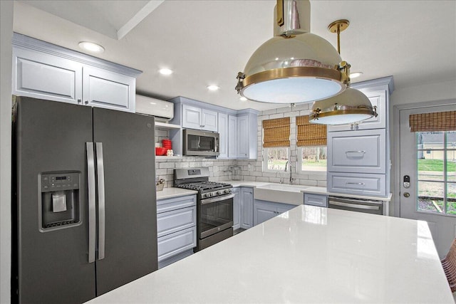 kitchen featuring a sink, light countertops, appliances with stainless steel finishes, and backsplash