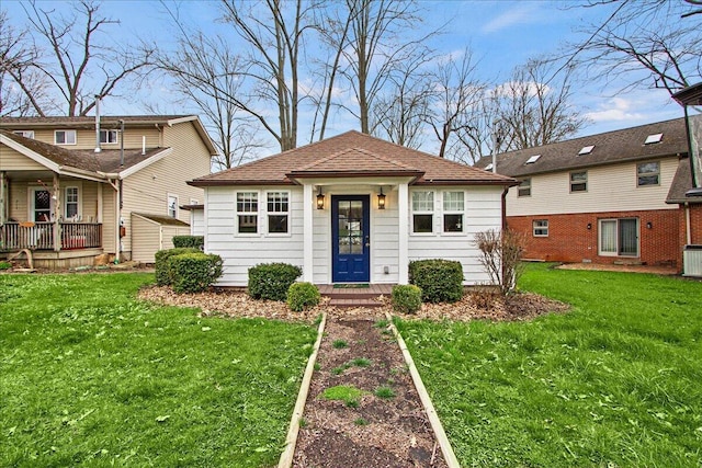 bungalow-style house with a front lawn, central AC unit, and a shingled roof