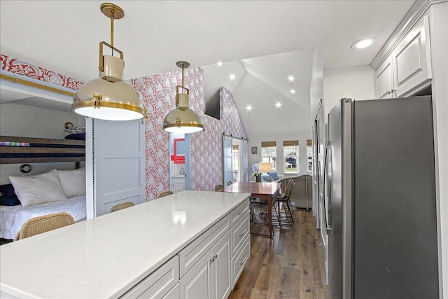 kitchen featuring wallpapered walls, open floor plan, freestanding refrigerator, light countertops, and white cabinetry