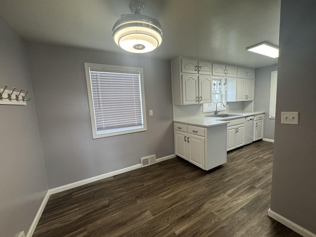 kitchen with white cabinetry, light countertops, a sink, and visible vents